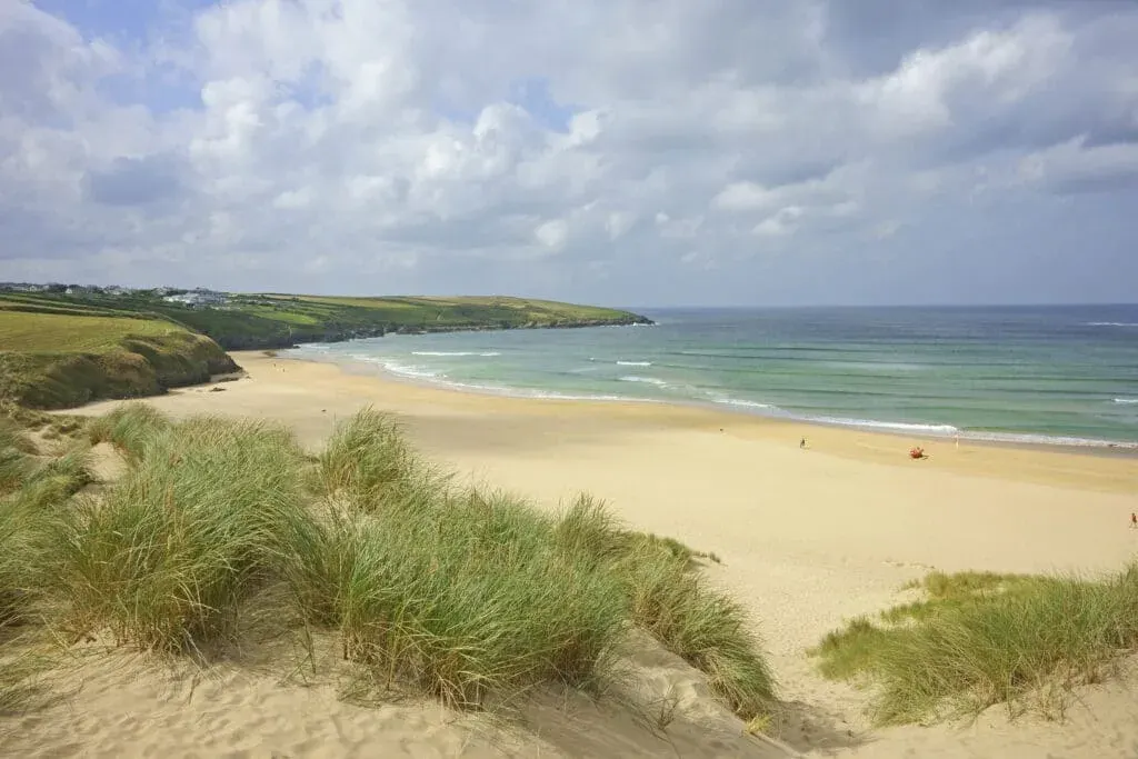 Crantock Bay Beach and Pentire Point showing an incoming tide.