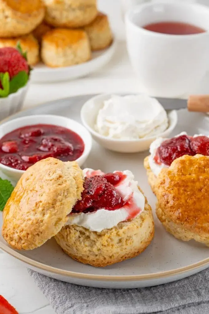 Homemade British Scones with cream cheese, strawberry jam and a cup of tea