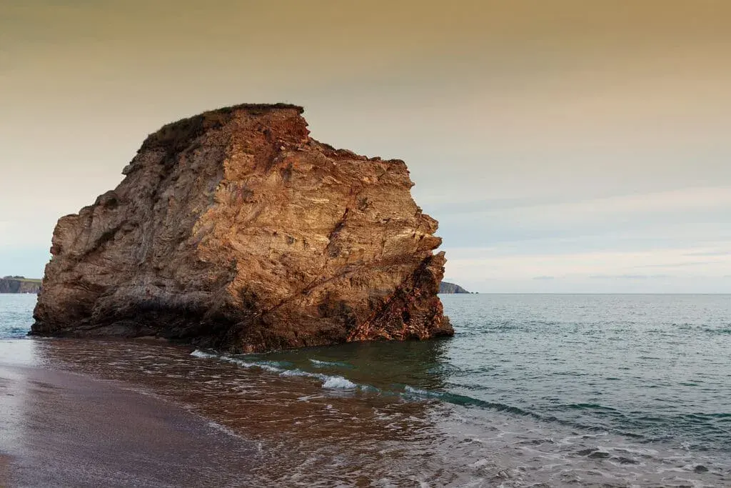 A beautiful sunset surrounds the giant rock at Carlyon Bay Beach near St Austell, Cornwall