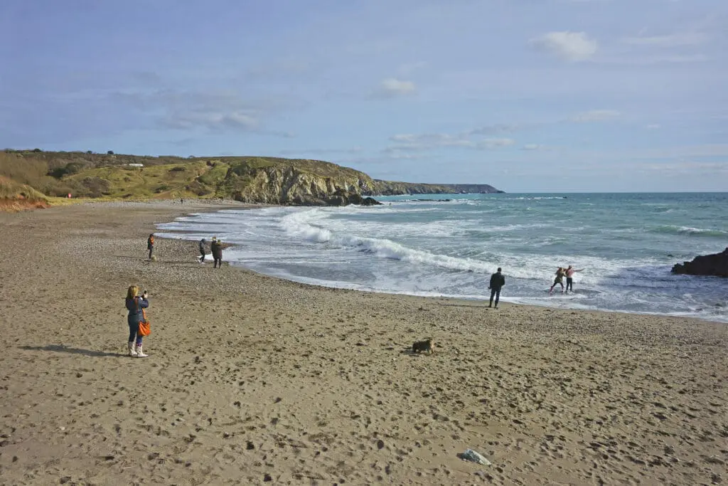 Kennack Sands Beach, Cornwall, in winter with families enjoying the surf, sand and sun