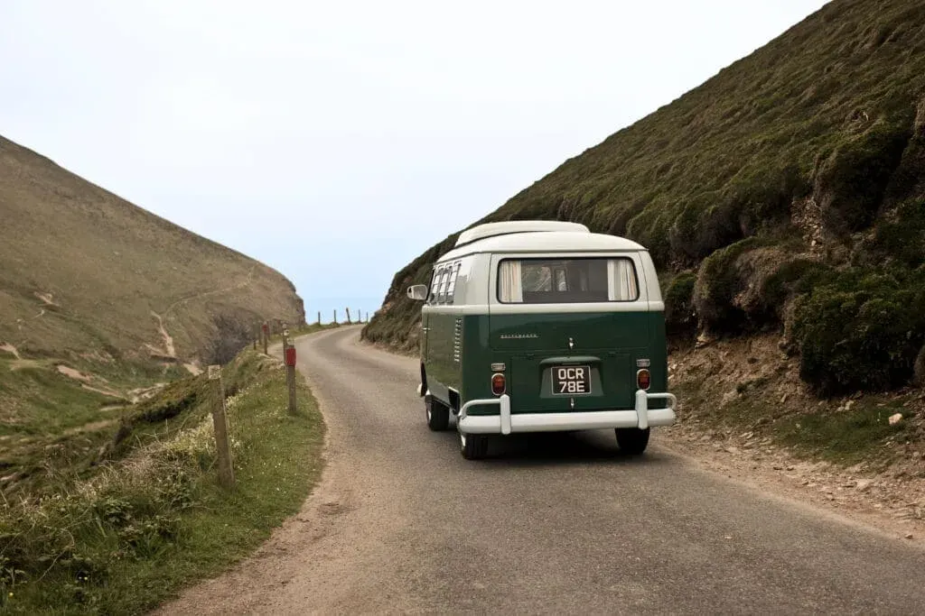 Moving to Cornwall – a VW campervan on coastal road, St Agnes, Cornwall