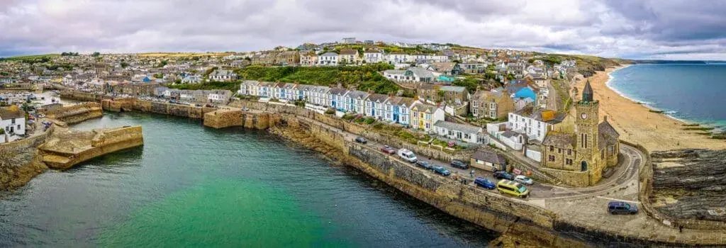 An aerial view of the harbour village of Porthleven and Porthleven Beach (on the right)