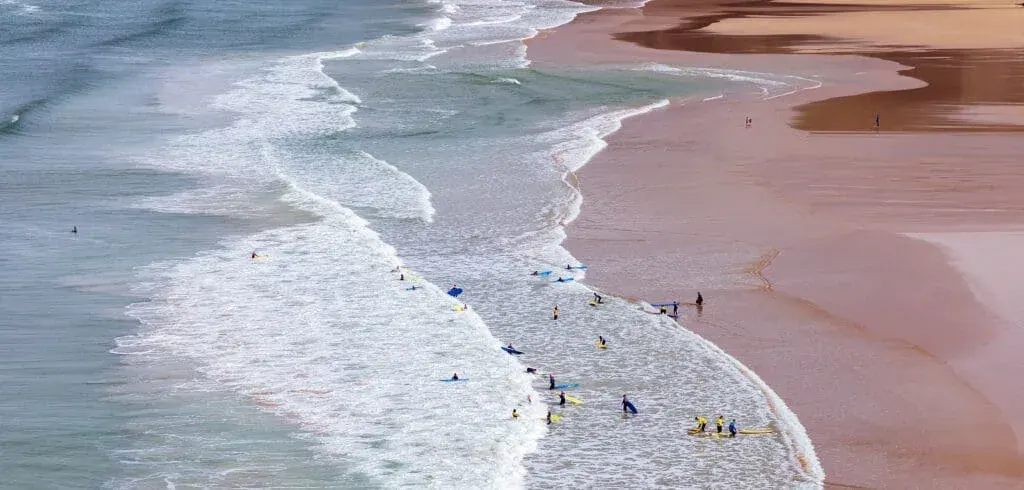 Surfers and swimmers enjoy the waves at Mawgan Porth Beach, Cornwall