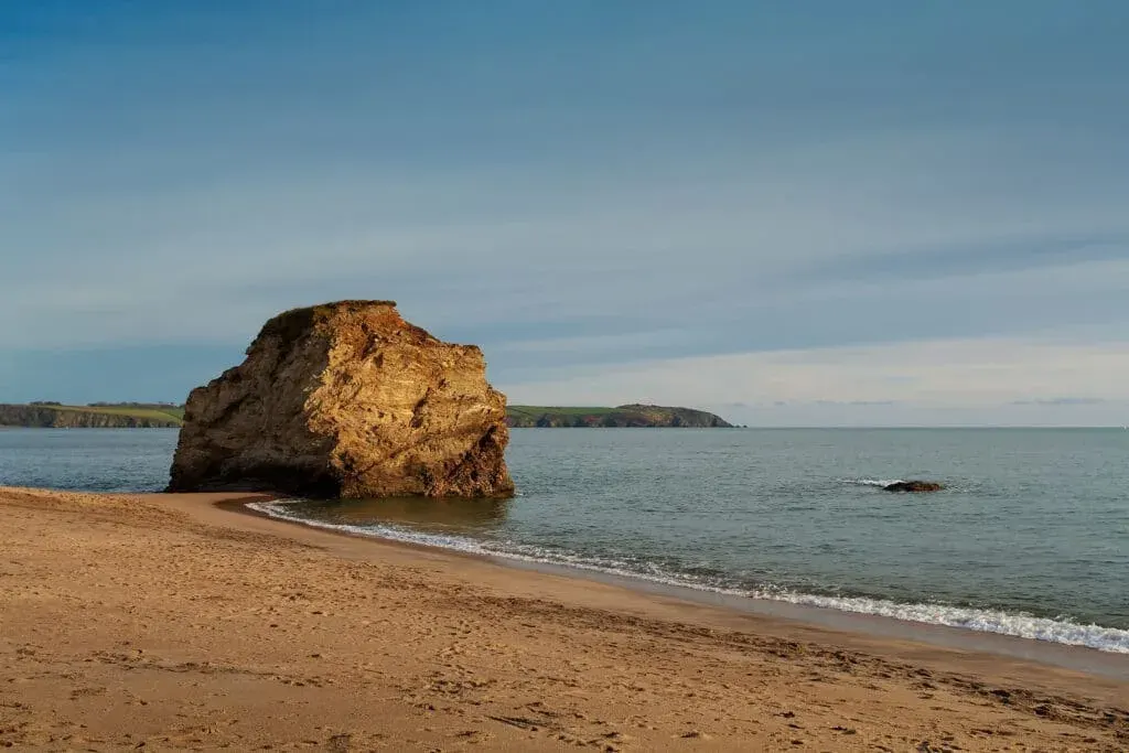 A giant rock rises from the sea at Carlyon Bay Beach, South Cornwall